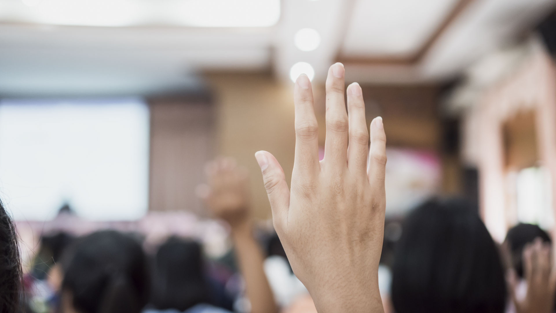 Audience raising hands up