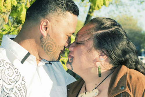 Maori couple connected in a traditional hongi