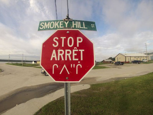 A stop sign in English, French, and Cree in Waskaganish, Quebec