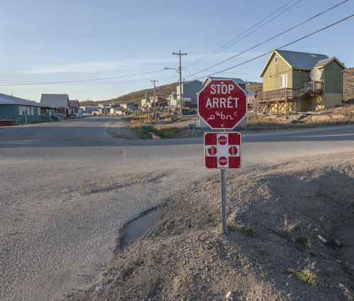 Un panneau d’arrêt écrit en anglais, en français et en inuktitut